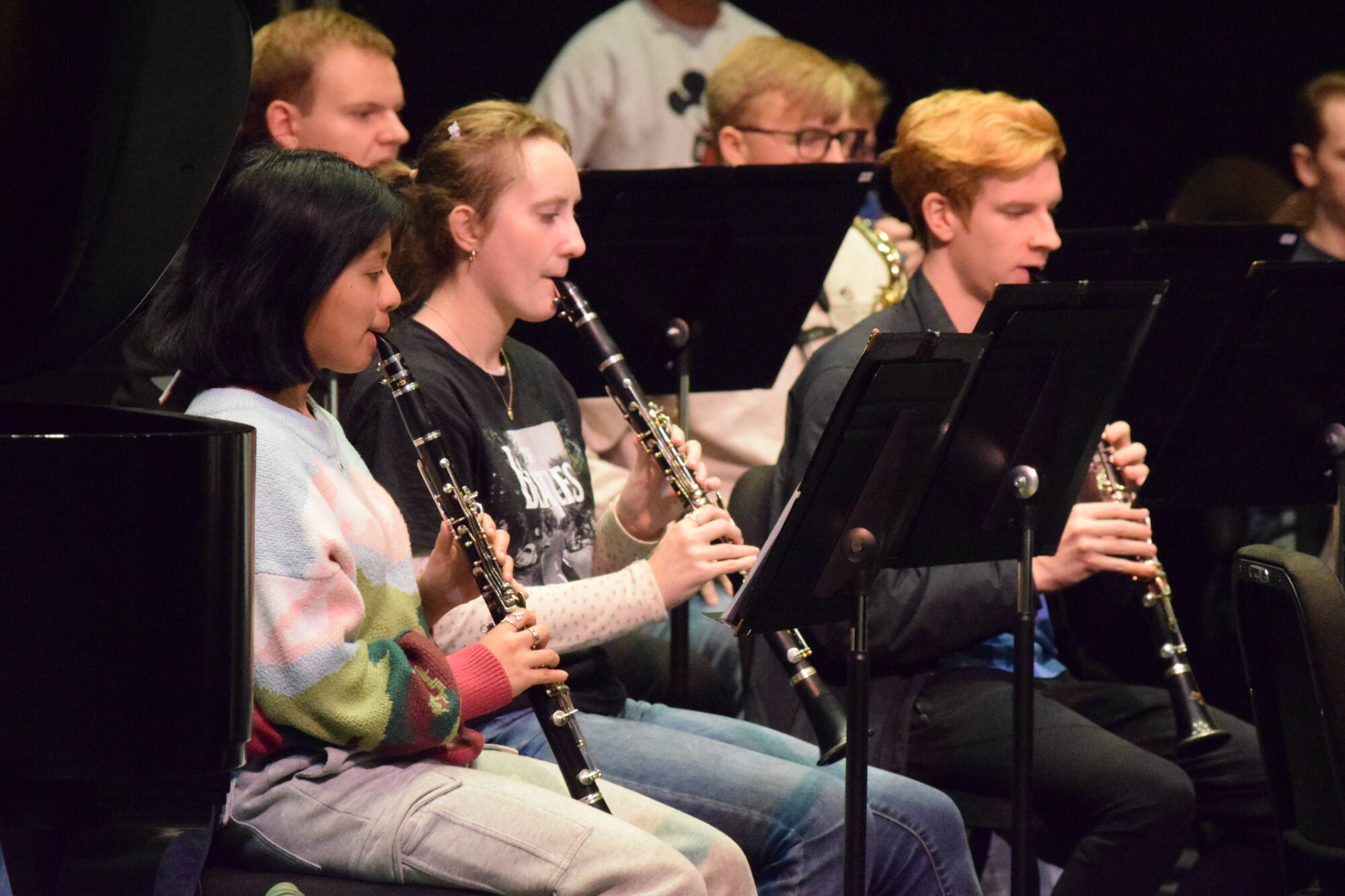three students playing clarinets